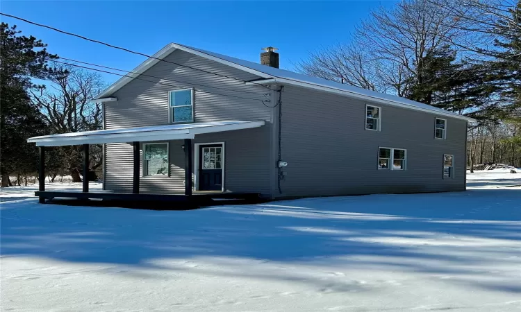 Snow covered property with a porch