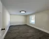 Empty room featuring a baseboard radiator and dark hardwood / wood-style floors