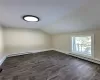 Bonus room featuring vaulted ceiling, dark hardwood / wood-style flooring, and baseboard heating