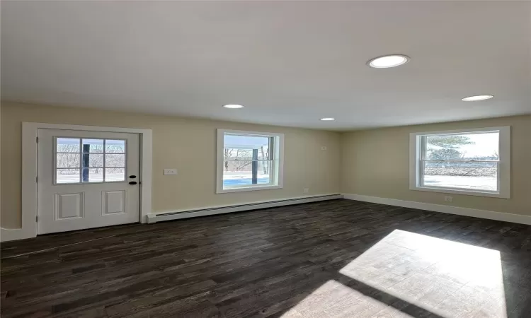 Foyer entrance featuring a baseboard heating unit and dark wood-type flooring