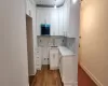 Kitchen with tasteful backsplash, white cabinetry, sink, and light wood-type flooring