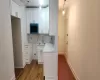 Kitchen featuring sink, crown molding, tasteful backsplash, hardwood / wood-style floors, and white cabinets