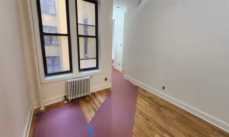 Unfurnished room with radiator and hardwood / wood-style floors