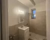 Bathroom featuring tile walls, vanity, tile patterned floors, and tiled shower