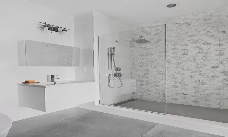 Bathroom with concrete flooring and tiled shower