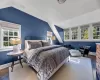 Bedroom featuring hardwood / wood-style floors, a baseboard radiator, vaulted ceiling, and multiple windows