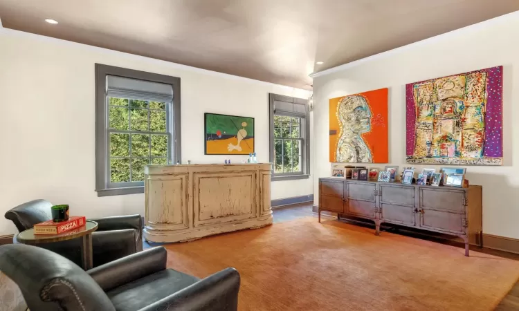 Sitting room with ornamental molding and carpet flooring