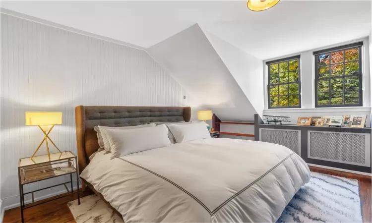 Bedroom with dark hardwood / wood-style floors and vaulted ceiling