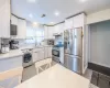 Kitchen featuring sink, washer / dryer, stainless steel appliances, and white cabinets