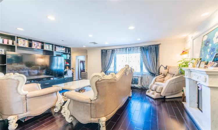 Living room with a premium fireplace and ornamental molding