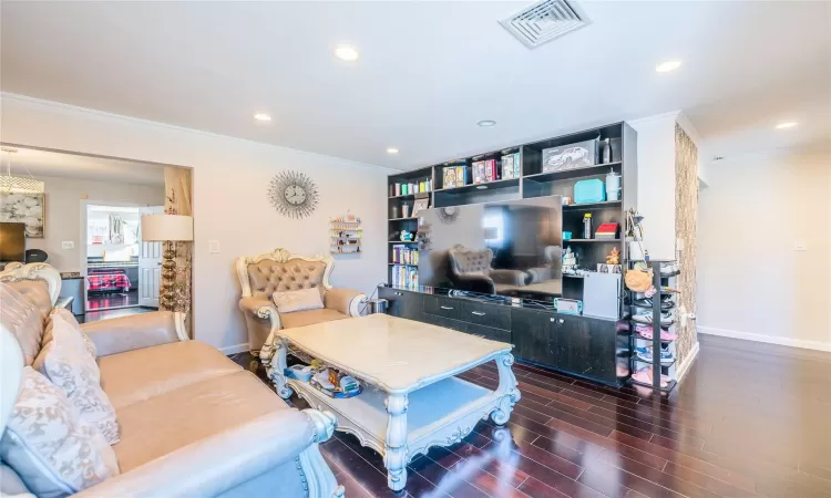 Living room featuring ornamental molding and dark hardwood / wood-style floors