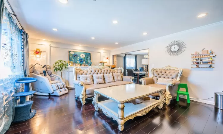 Living room with ornamental molding and dark wood-type flooring