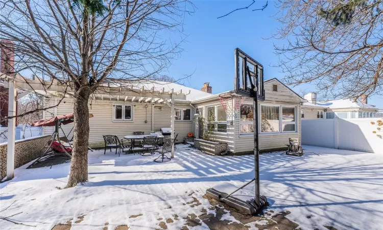 Snow covered house with a pergola