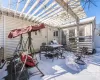 Snow covered patio with a pergola