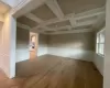 Spare room featuring beamed ceiling, wood-type flooring, and coffered ceiling