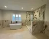 Bathroom with independent shower and bath and tile walls