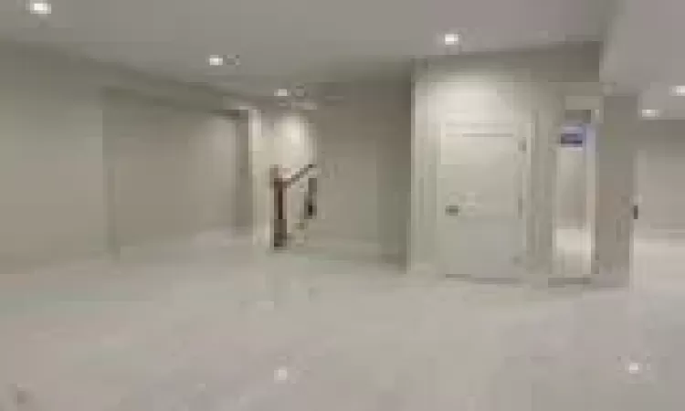 Basement with light hardwood / wood-style floors