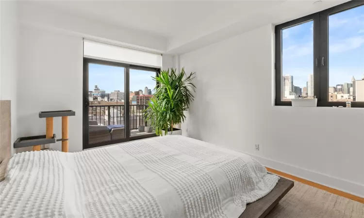 Bedroom with hardwood / wood-style floors and access to outside