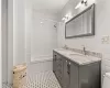 Bathroom featuring vanity, toilet, and tile walls