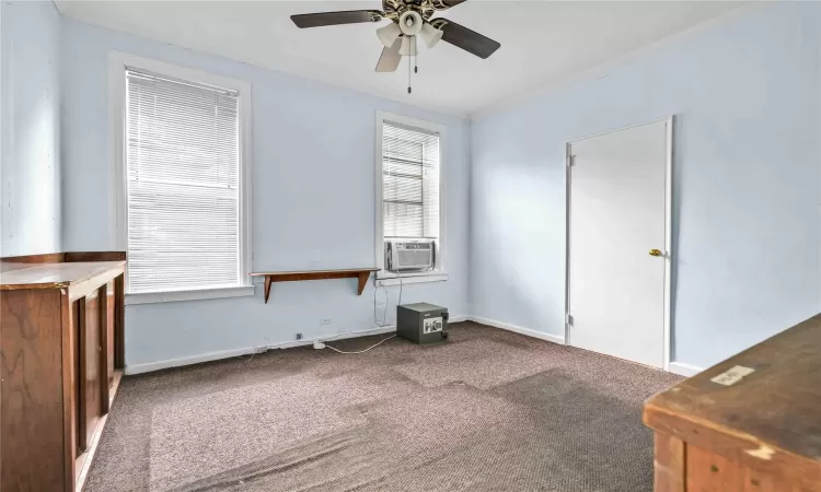 Spare room featuring ornamental molding, carpet flooring, cooling unit, and ceiling fan