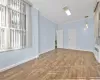 Unfurnished living room featuring crown molding, radiator, and hardwood / wood-style flooring