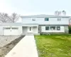 View of front facade with a garage and a front lawn