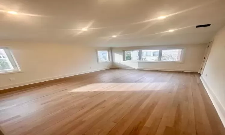 Spare room with vaulted ceiling and light hardwood / wood-style floors