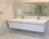 Bathroom with tiled shower and vanity