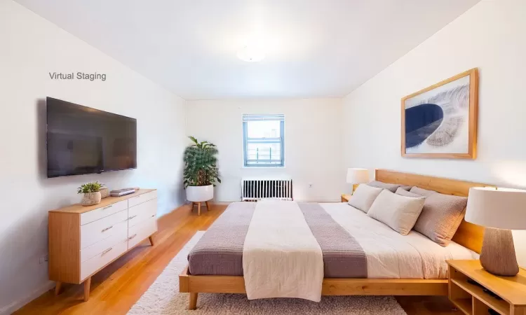 Bedroom featuring light hardwood / wood-style flooring and radiator