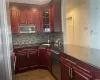 Kitchen with sink, backsplash, stainless steel appliances, and dark stone counters