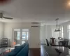 Dining room featuring a wall unit AC, dark hardwood / wood-style floors, ceiling fan, and french doors