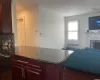 Kitchen featuring radiator, dark hardwood / wood-style flooring, decorative backsplash, ceiling fan, and kitchen peninsula