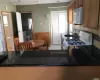 Kitchen featuring sink, white appliances, kitchen peninsula, and light tile patterned flooring