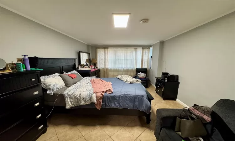 Tiled bedroom with ornamental molding and vaulted ceiling