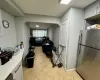 Kitchen featuring white cabinets, light tile patterned floors, and stainless steel fridge