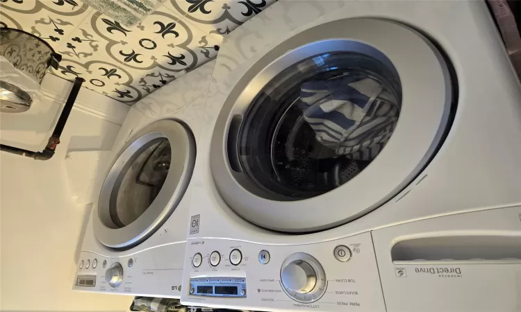 Clothes washing area featuring tile patterned floors and independent washer and dryer