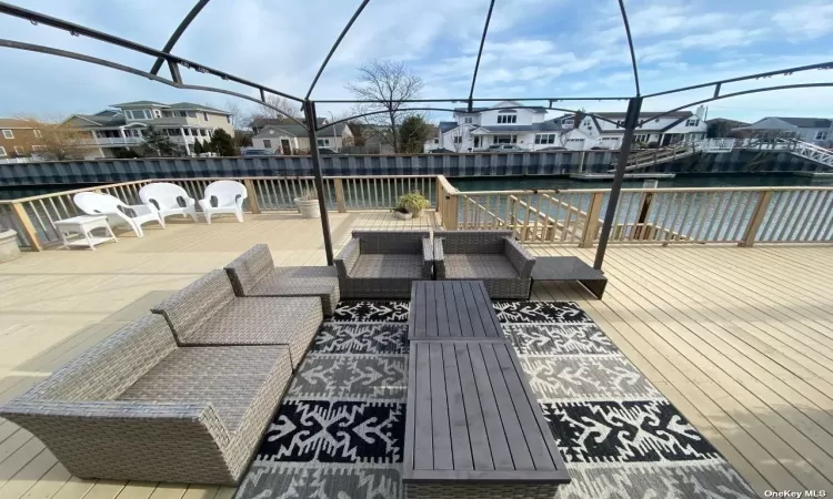 View of patio with a deck with water view and an outdoor living space