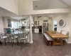 Dining area featuring washer / dryer, high vaulted ceiling, dark hardwood / wood-style floors, beverage cooler, and decorative columns