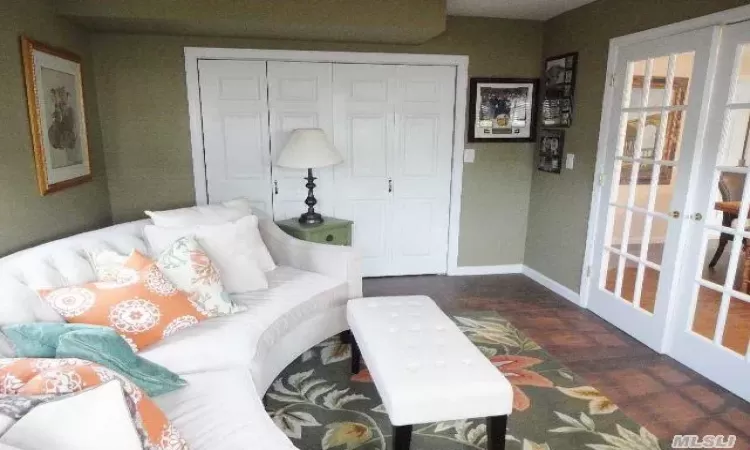 Living room with dark wood-type flooring and french doors