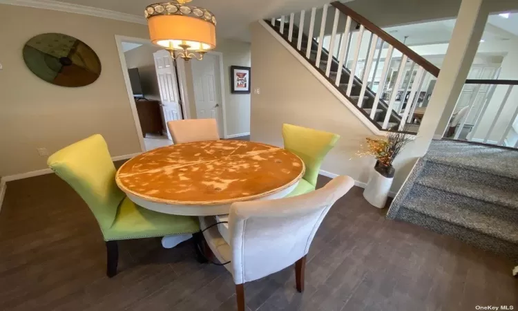 Dining space featuring crown molding, a chandelier, and dark hardwood / wood-style flooring