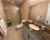 Bathroom featuring a shower with door, tile patterned flooring, vanity, a baseboard radiator, and toilet