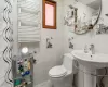 Bathroom featuring radiator, tile walls, and toilet