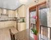 Kitchen featuring cream cabinets, stainless steel appliances, and wall chimney exhaust hood