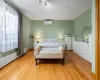 Bedroom featuring an AC wall unit and light wood-type flooring