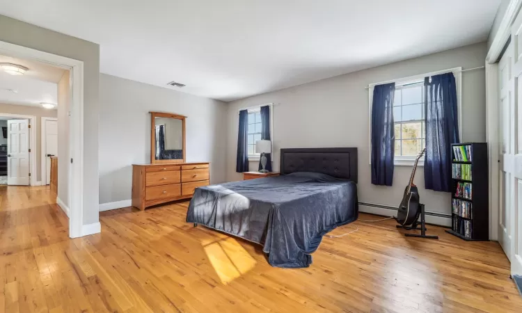 Bedroom featuring baseboard heating and light wood-type flooring