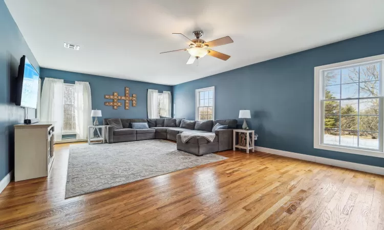 Living room featuring plenty of natural light, ceiling fan, and light wood-type flooring