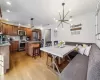 Kitchen with a kitchen bar, a center island, appliances with stainless steel finishes, pendant lighting, and light hardwood / wood-style floors