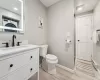 Bathroom with vanity, toilet, and baseboard heating