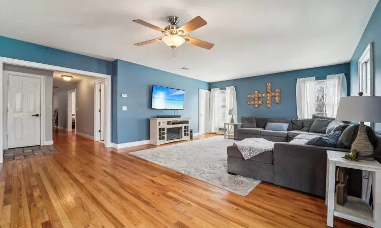 Living room featuring wood-type flooring and ceiling fan