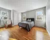 Bedroom with multiple windows, a baseboard heating unit, and light hardwood / wood-style floors